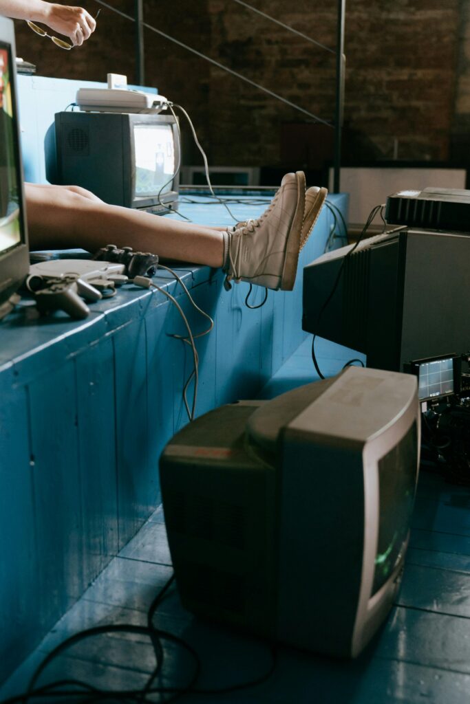 pexels-photo-4842575-4842575 A nostalgic indoor scene of vintage video game consoles and TV screens with a focus on retro aesthetics.